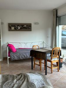 a bedroom with a bed and a table and chairs at LA BASTIDETTE PROVENçALE in Jouques