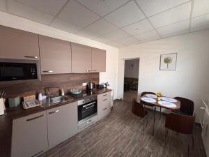 a kitchen with a table and a dining room at Cozy place in Stará Ľubovňa