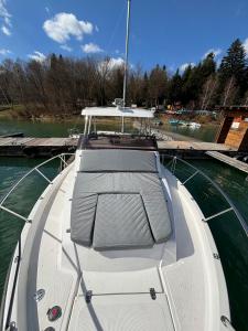a boat sitting in the water at a dock at Silent Jacht Solina in Polańczyk +5 photos