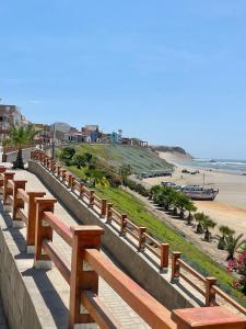 a row of wooden benches next to the beach at Mamá María Surf House in Puerto Chicama