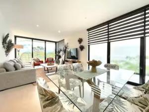 a living room with a glass table and chairs at Casa CooLas in Cozumel