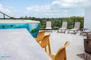 a patio with chairs and a table and a swimming pool at Casa CooLas in Cozumel