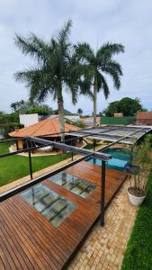 a wooden deck with a pool and palm trees at Hotel dos Príncipes - Guarujá in Guarujá