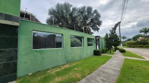 a green building on the side of a street at Hotel dos Príncipes - Guarujá in Guarujá