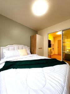 a bedroom with a large white bed with a window at Impact poppula P1 by เจี๊ยบ in Thung Si Kan