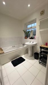 a white bathroom with a tub and a sink at Golden House in Waterbeach +13 photos