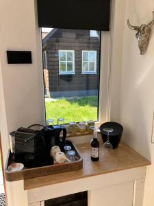 a kitchen with a counter with a window at 't Hûske in Venhorst