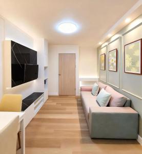 a living room with a couch and a flat screen tv at Impact poppula P1 by เจี๊ยบ in Thung Si Kan