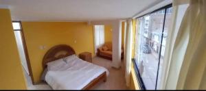 a small bedroom with a bed and a window at Cozy Apartment in PUNO in Puno