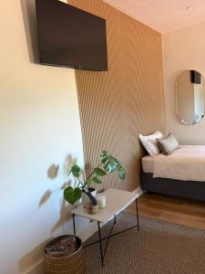 a room with a bed and a table with a plant at Vue de Valleé in Wellington