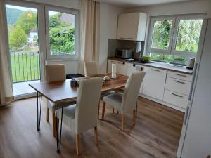 a kitchen and dining room with a wooden table and chairs at Ferienwohnung Buchenblatt in Simmerath