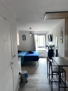 a bedroom with a bed and a table and a desk at Les logis de Paray - app 211 in Paray-le-Monial