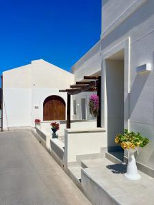 a white building with flowers in vases on the steps at Asmara 10 in Trapani