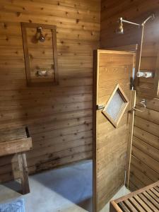 a wooden room with a shower and a door at Modern studio Cabin in Tok