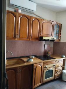 a kitchen with wooden cabinets and a microwave at Moon e Sky in Tirana