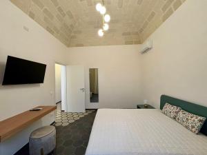 a bedroom with a bed and a flat screen tv at Asmara 10 in Trapani