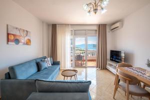 a living room with a blue couch and a table at Parid Apartments in Sarandë