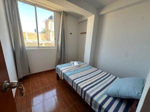 a small room with a bed and a window at Mamá María Surf House in Puerto Chicama