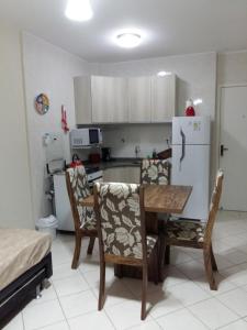 a kitchen with a table and chairs and a refrigerator at Sol da Cachoeira in Florianópolis +12 photos