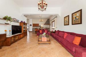 a living room with a red couch and a table at Refugio del Volcán by Tropical Host in Uga