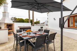 a black table with chairs and an umbrella on a patio at Refugio del Volcán by Tropical Host in Uga