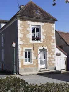 a building with a white door and a window at Gite Le Cozy in Val-au-Perche