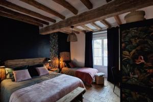a bedroom with two beds and a window at Gite Le Cozy in Val-au-Perche