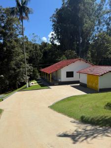 a building with a red roof next to a road at Vale Verde in Jacutinga
