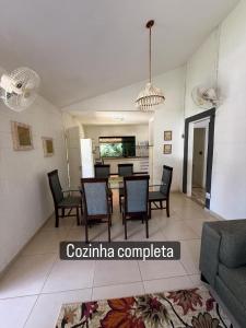 a living room with a table and chairs and a kitchen at Vale Verde in Jacutinga