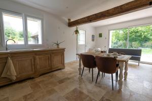 a dining room with a table and some windows at Ô Bois Jer'Home in Bois-Jérôme-Saint-Ouen