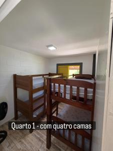a room with three bunk beds and a mirror at Vale Verde in Jacutinga +5 photos