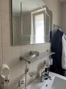 a bathroom with a sink and a mirror at Pensiunea Beciul Vechi in Mileştii Mici +22 photos