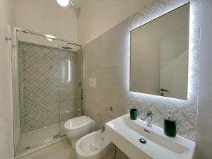 a bathroom with a sink and a toilet and a mirror at Asmara 10 in Trapani +43 photos