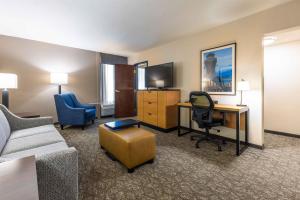 a hotel room with a couch and a desk and chair at Drury Inn & Suites St. Louis Airport in Edmundson