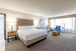 a hotel room with a large bed and a chair at Drury Inn & Suites St. Louis Airport in Edmundson +46 photos