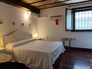 a bedroom with a large bed and a window at Almarè Confort Rooms in Terrasini