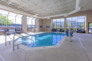 a large pool in a building with chairs and a table at Drury Inn & Suites St. Louis Airport in Edmundson