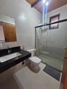 a bathroom with a toilet and a sink and a shower at Loft da Árvore in Petrópolis