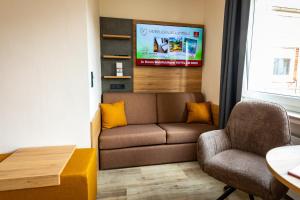 ein Wohnzimmer mit Sofa und Sessel in der Unterkunft Hotel am Park Bad Driburg in Bad Driburg