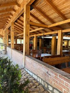 a wooden pavilion with tables and a brick wall at Motel Alibey in Bugojno