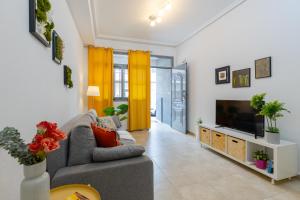 a living room with a couch and a television at Enjoy life in our apartment. Wifi Parking in Guardamar del Segura