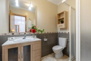 a bathroom with a toilet and a sink and a mirror at Enjoy life in our apartment. Wifi Parking in Guardamar del Segura +14 photos
