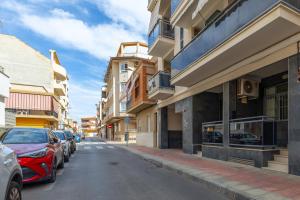 a city street with parked cars and buildings at Enjoy life in our apartment. Wifi Parking in Guardamar del Segura