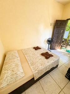 a bedroom with a bed with a blanket and a door at Recanto Mozão in Angra dos Reis