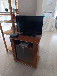 a tv sitting on a wooden stand in a room at chez MAG et YANN in La Séauve-sur-Semène