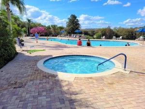a swimming pool with a hot tub in a brick patio at Andy's Hideaway at Bahama Bay - Sage Vacations in Kissimmee