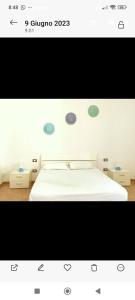 a bedroom with a white bed with blue circles on it at Casa Arborea in Sennori