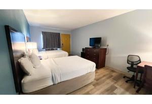 a hotel room with a bed and a television at Studio 6 Suites - Tiffin, OH in Tiffin