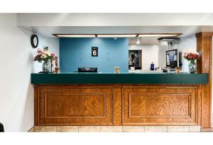 a bar with wooden cabinets and a blue wall at Studio 6 Suites - Tiffin, OH in Tiffin