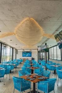 a dining room with blue chairs and wooden tables at Mex Hoteles in Cancún